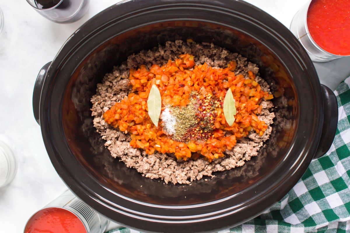 meat mixture, veggies mixture, seasonings and bay leaves in a slow cooker