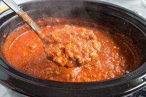 Slow Cooker Bolognese Sauce in a crockpot with a ladle