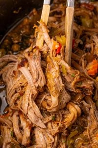 Slow Cooker Chicago Style Pulled Pork Tenderloin in crockpot with tongs