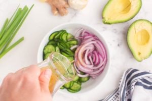 pouring dressing over cucumbers