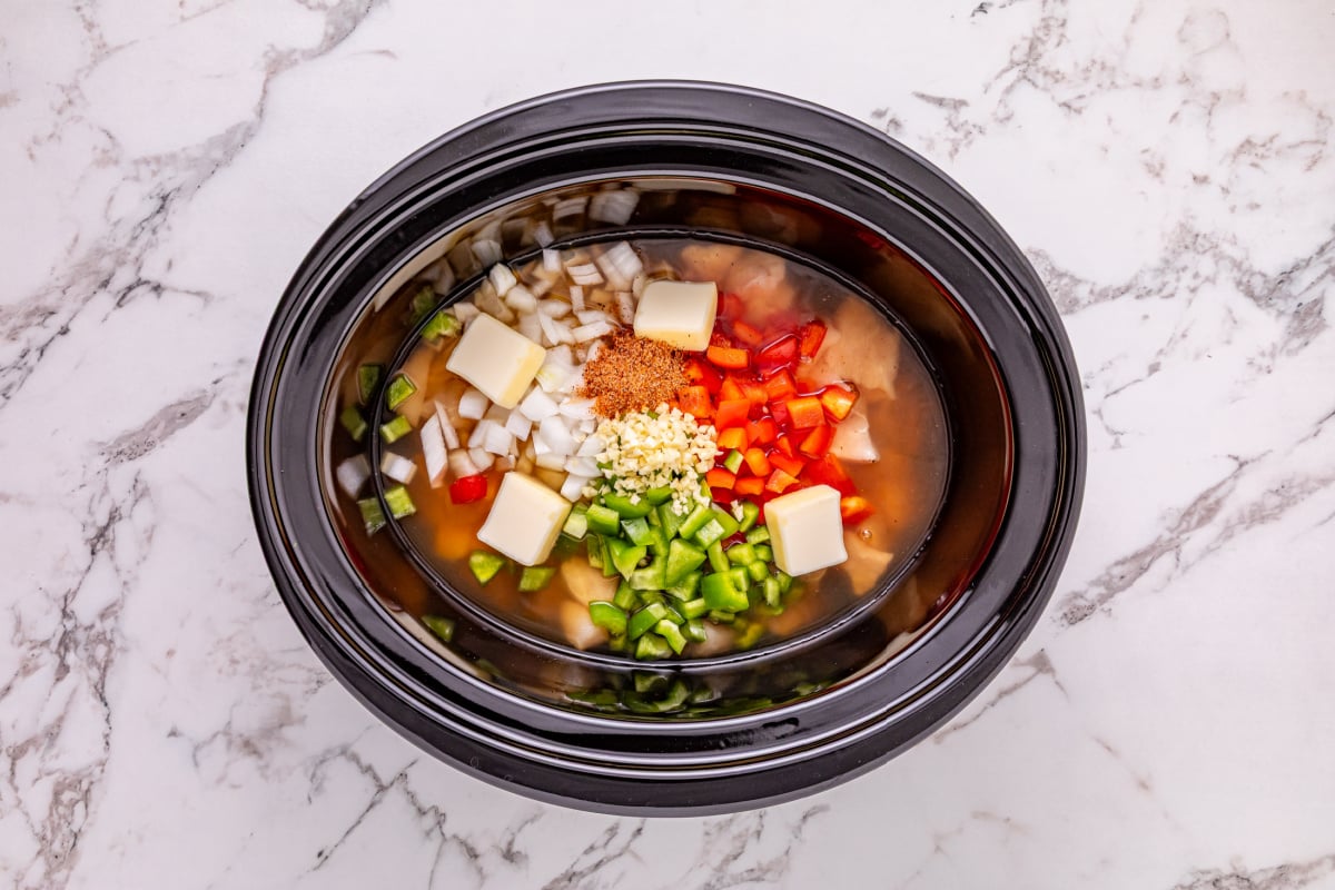 chicken breasts, onion, bell peppers, garlic, chicken broth, butter, and cajun seasoning in slow cooker
