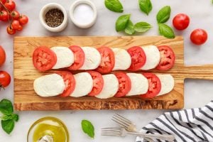 sliced cheese and tomatoes on a cutting board