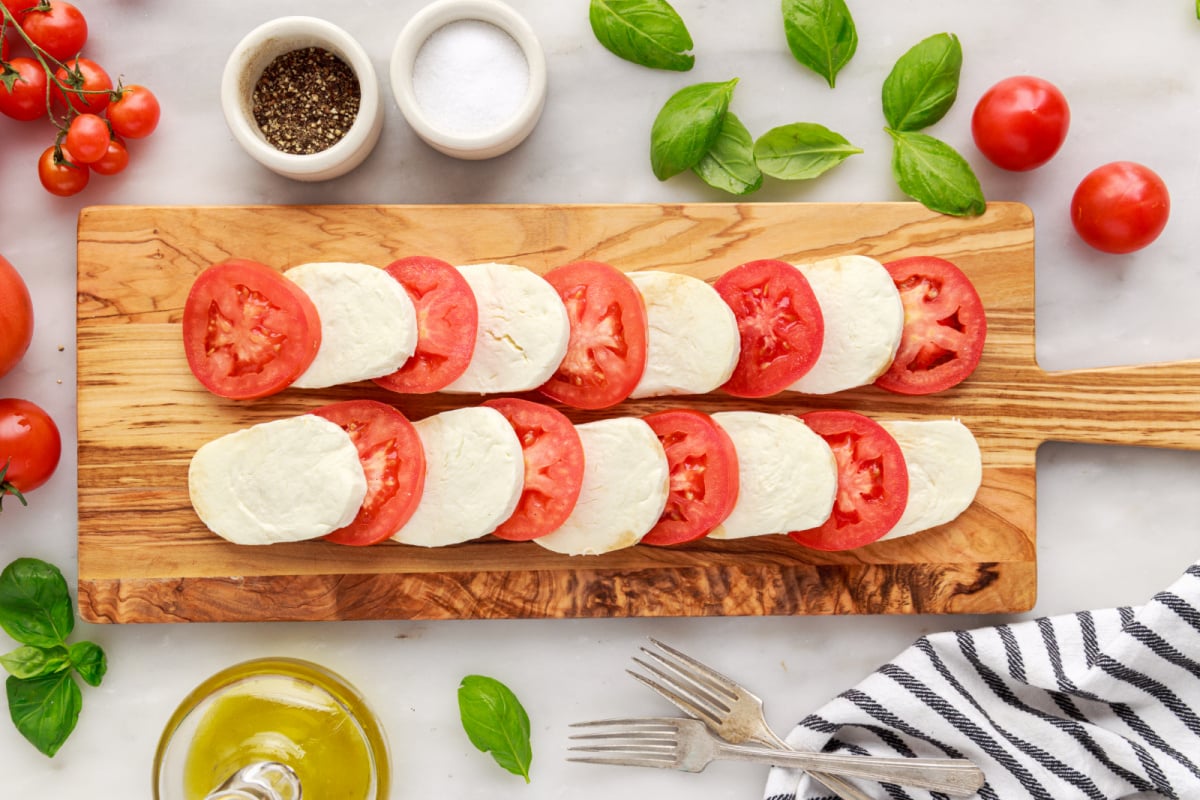 sliced cheese and tomatoes on a cutting board