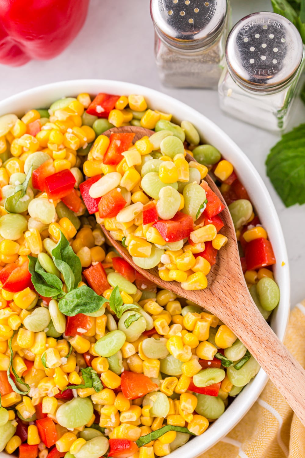 Corn Succotash in a bowl with a wooden spoon