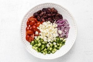 tomatoes, cucumber, olives, and red onion, then combine them in a large bowl with the feta cheese