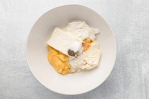 cream cheese, ricotta cheese, sour cream, cream of chicken soup, ranch seasoning, garlic powder, salt and pepper in a bowl
