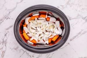 carrots onion and garlic added to slow cooker