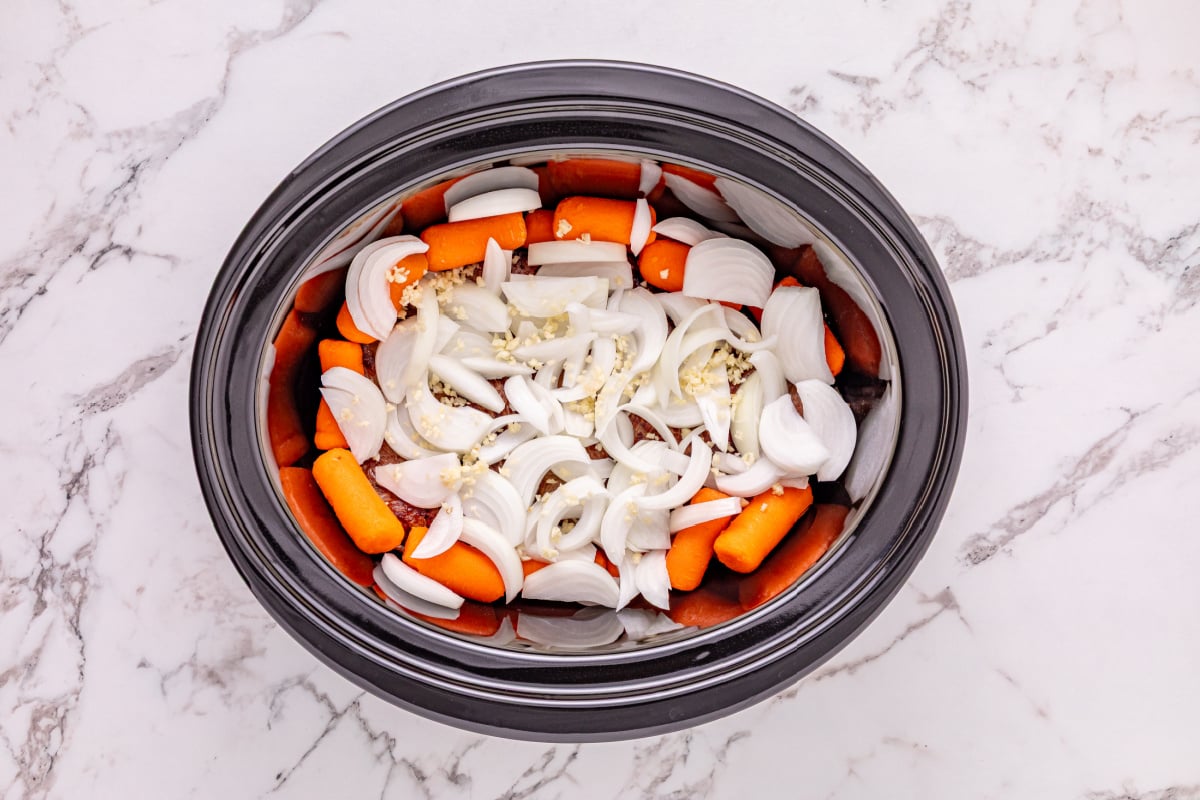 carrots onion and garlic added to slow cooker