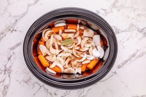 sauce added to slow cooker and bay leaf added