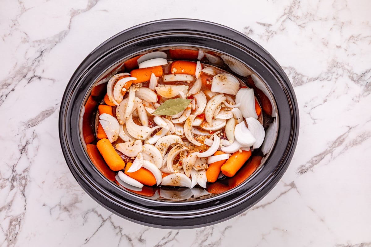 sauce added to slow cooker and bay leaf added