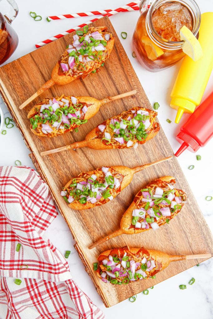 loaded chili corn dogs on a cutting board