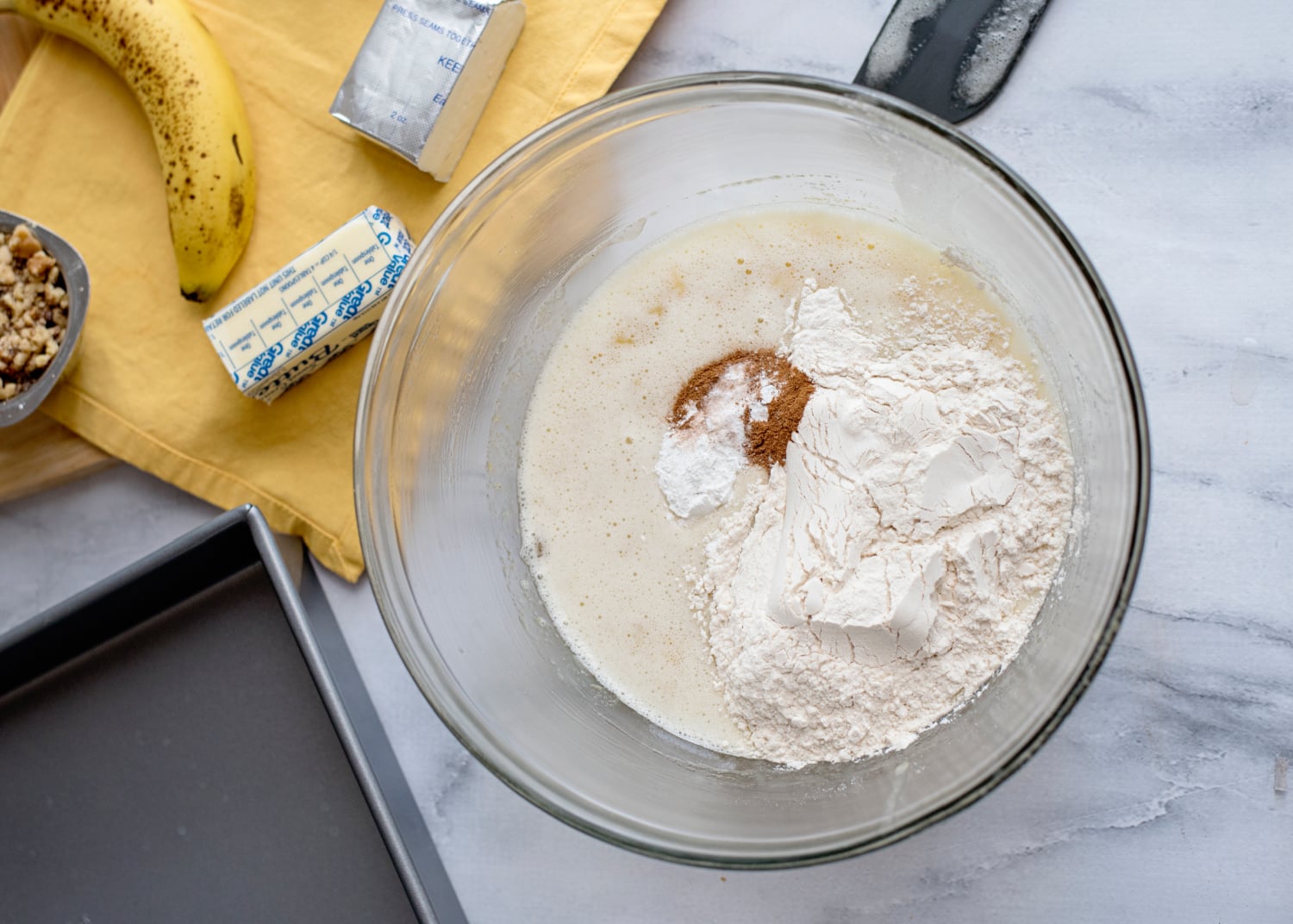 flour, baking powder, baking soda, cinnamon, and salt added to bowl