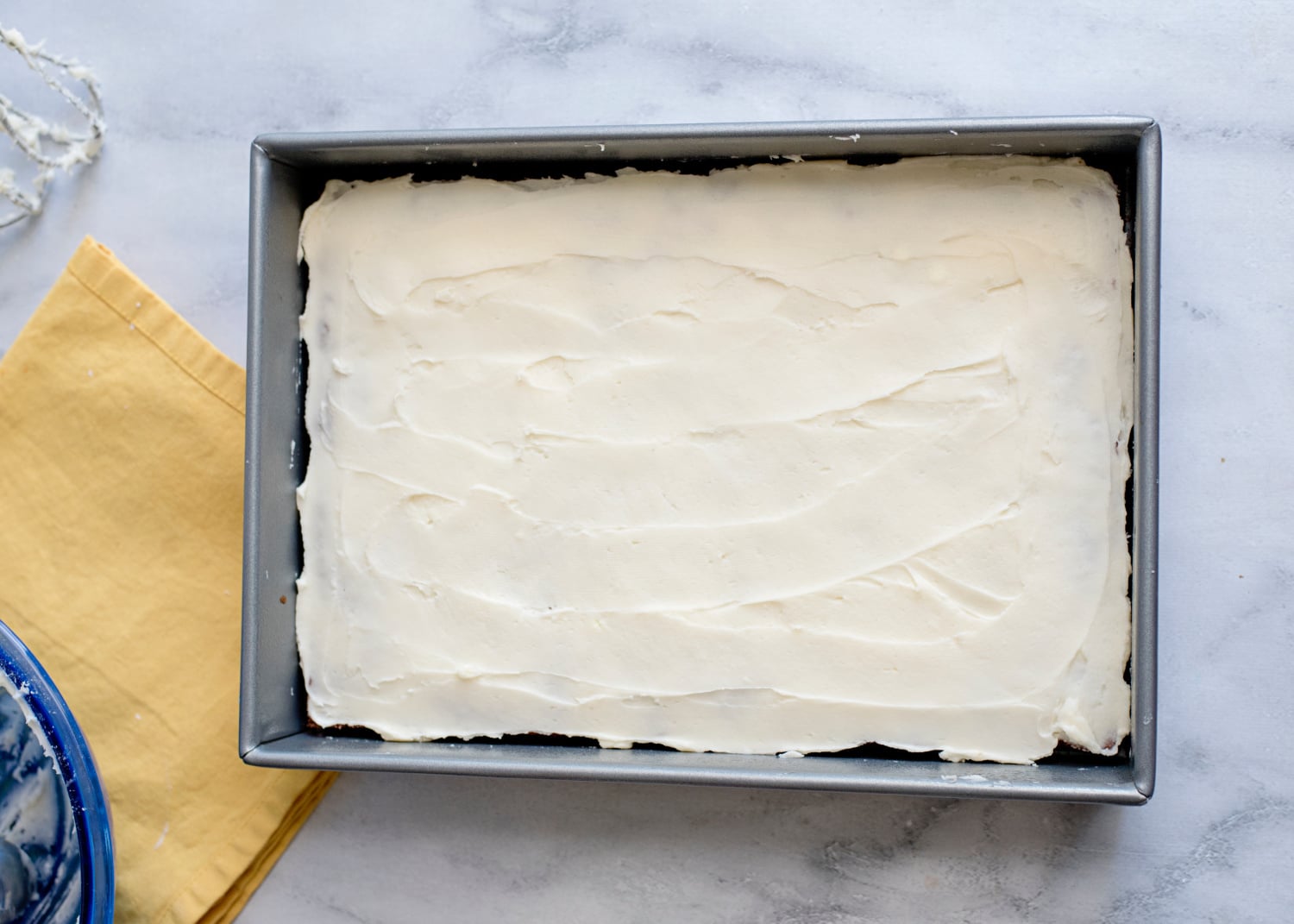 cream cheese frosting spread over cake