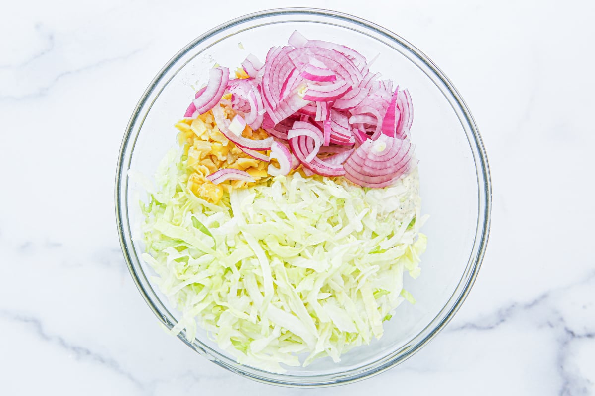 shredded lettuce, sliced red onion and pepperoncini peppers in a bowl