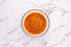 beef broth, soy sauce, cornstarch, sugar, red pepper flakes, salt, and pepper mixed in a bowl