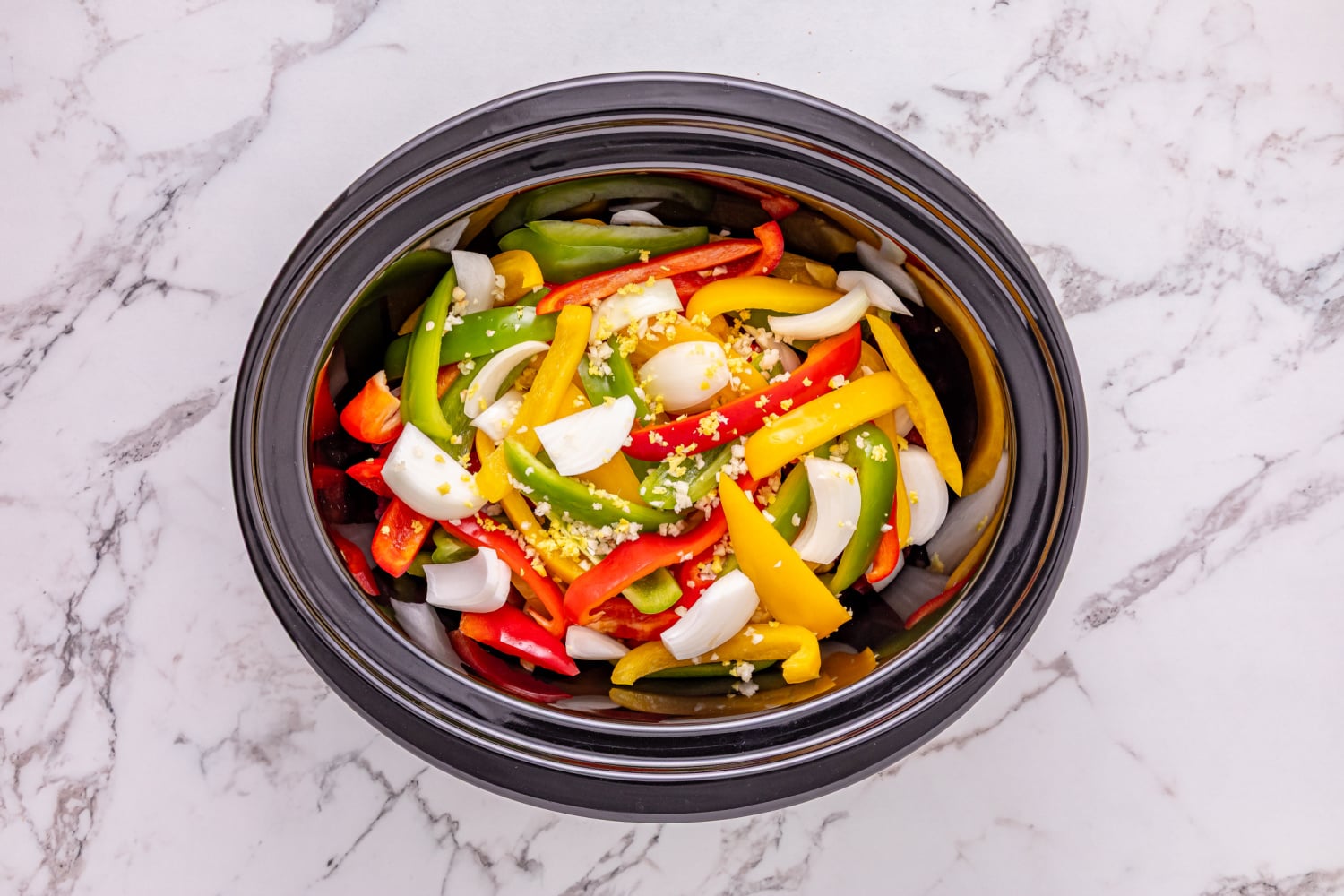 sliced bell peppers, onion, garlic, and ginger added to slow cooker