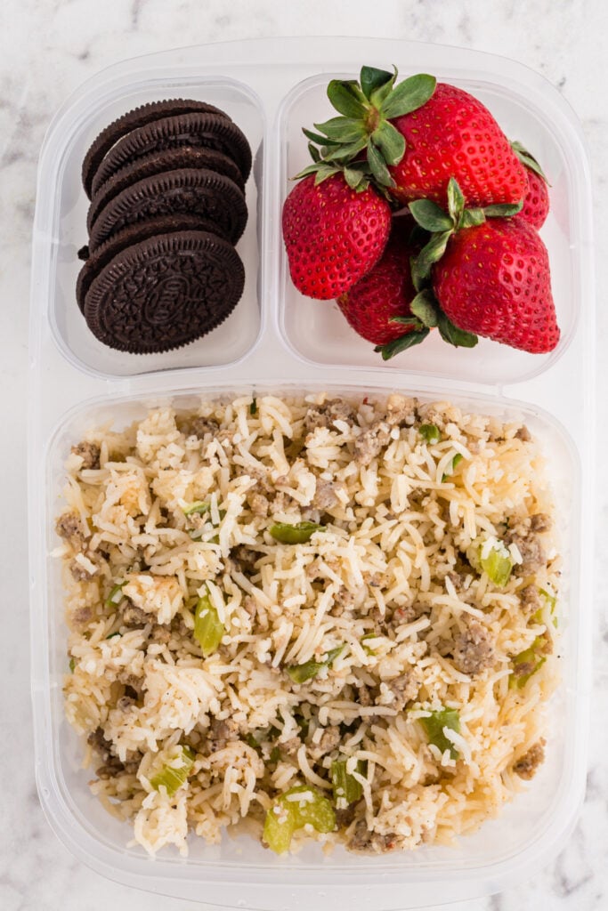 Dirty Rice with Sausage packed in a lunchbox with cookies and fruit