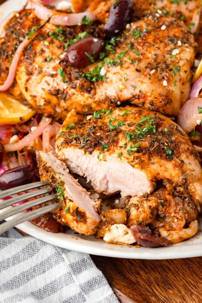 piece of greek chicken with a piece cut off