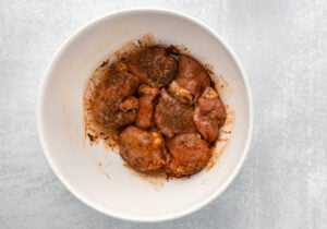 chicken marinating in a bowl
