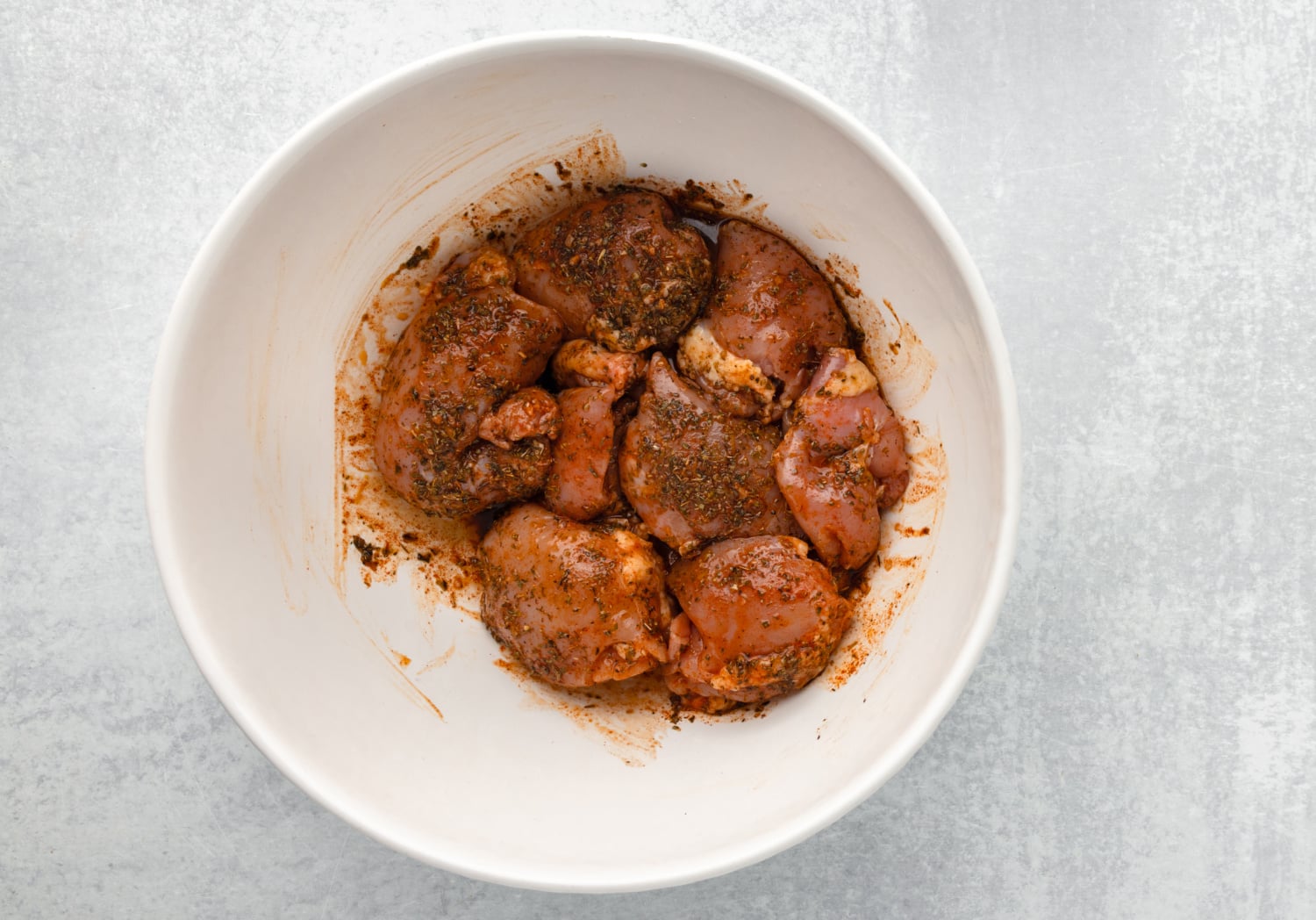 chicken marinating in a bowl