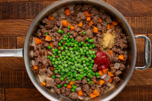 frozen peas, ketchup, water or beef broth, Worcestershire sauce, garlic powder, Italian seasoning, salt, and black pepper added to pan