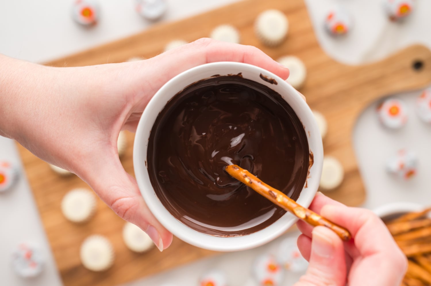 pretzel stick being dipped into chocolate